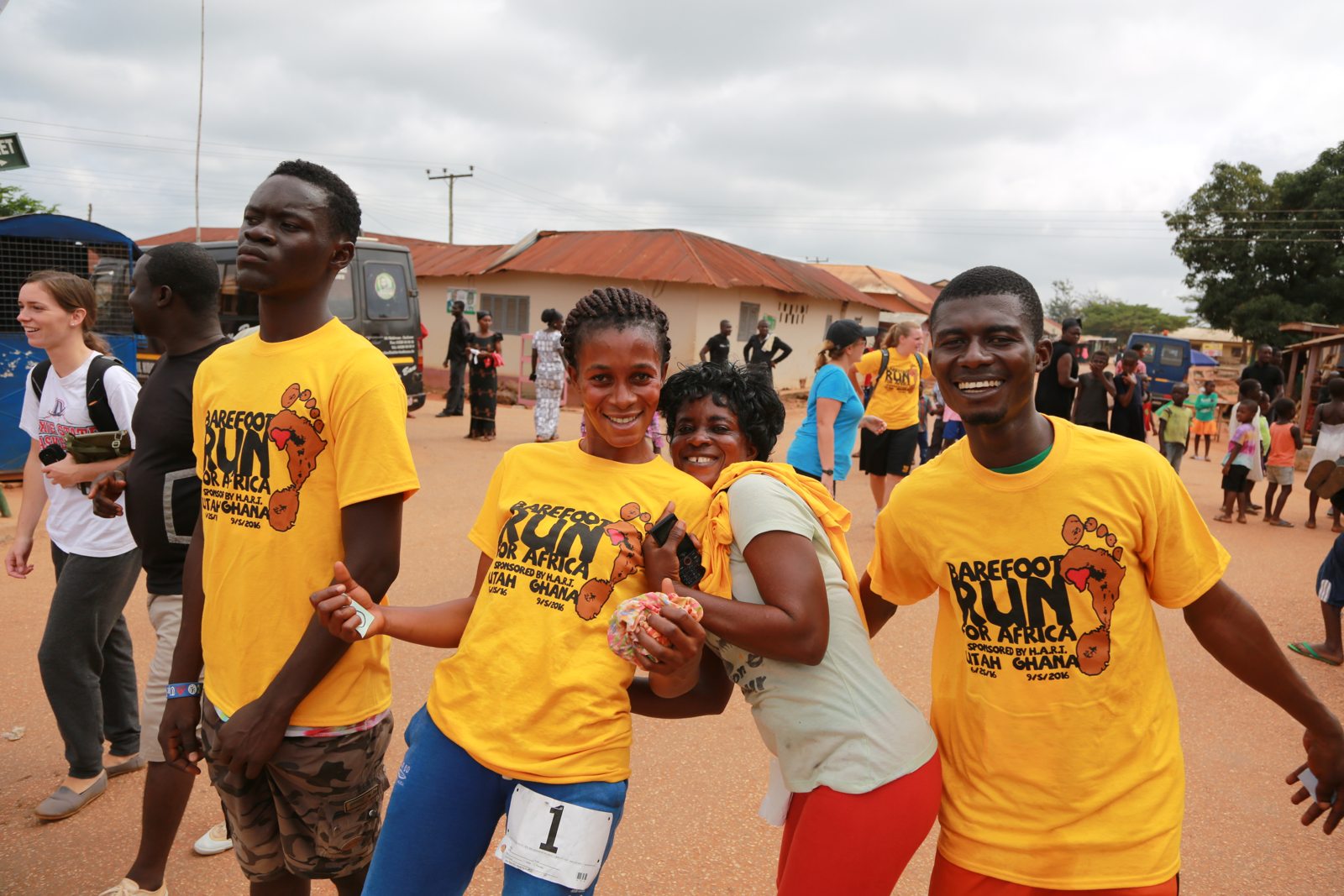 Four runners walking arm in arm in Barefoot Run shirts