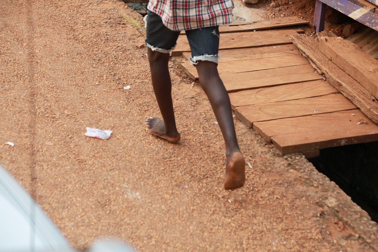 A barefoot child mid-stride on the village road