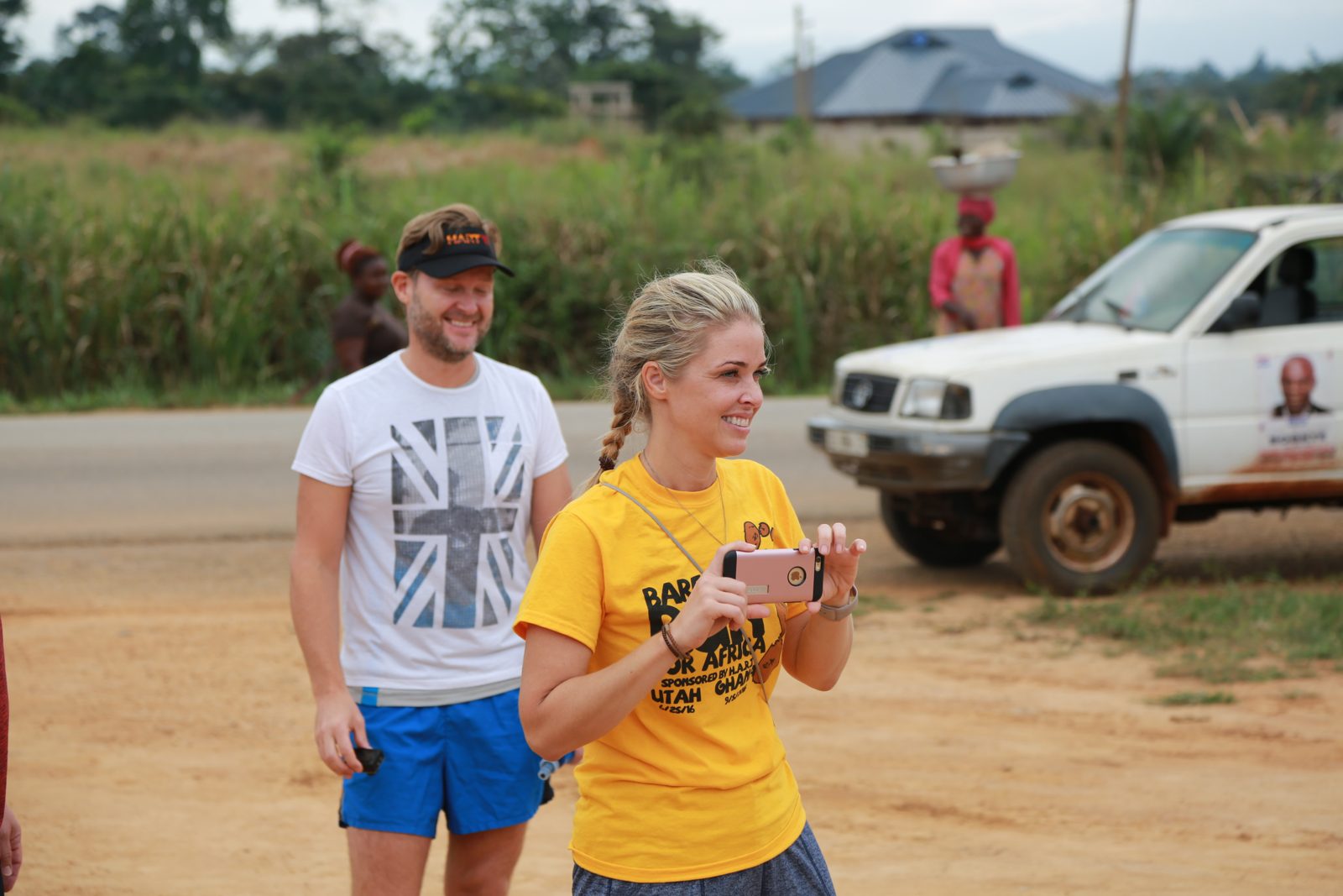 A volunteer in a race shirt filming the course on her phone