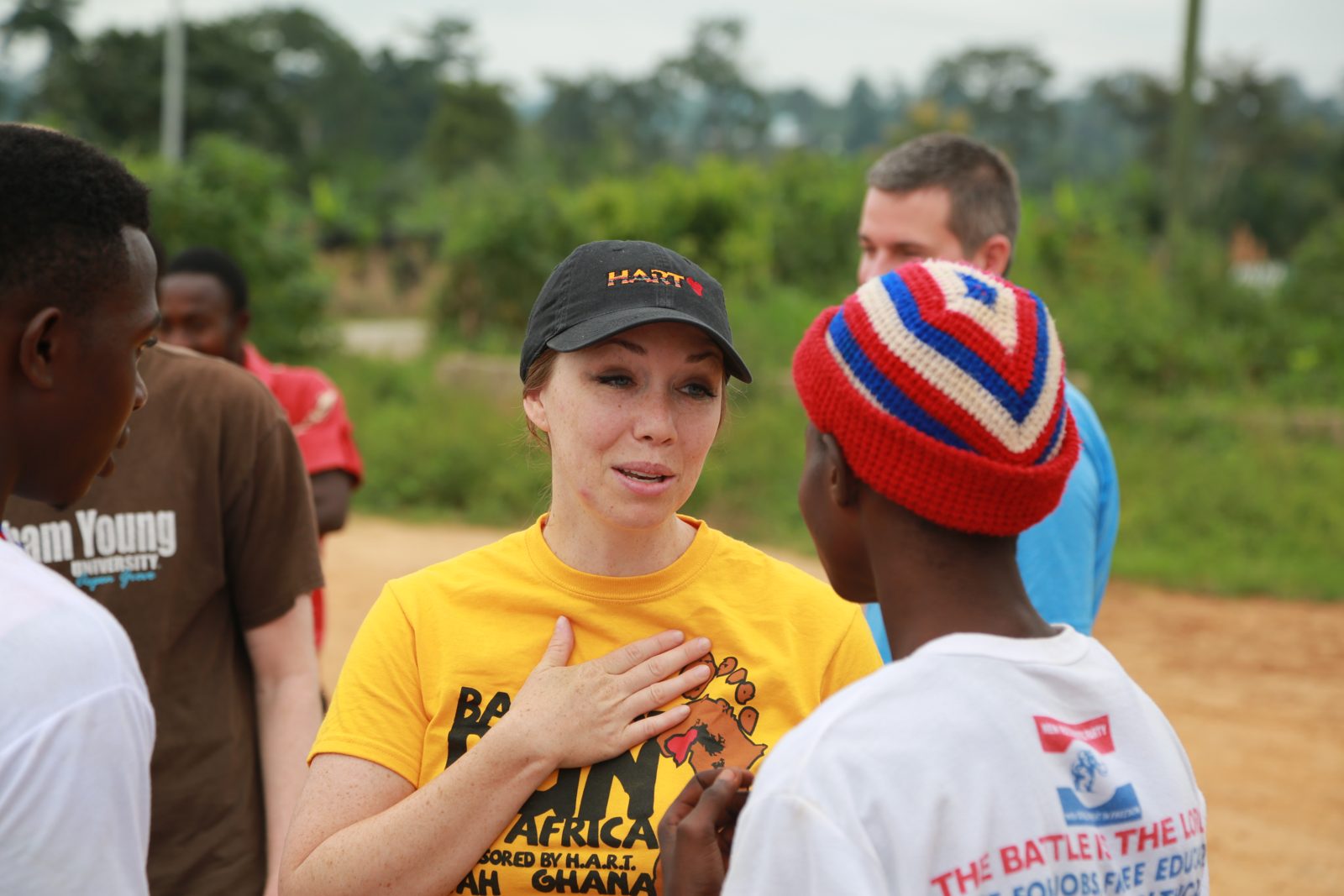 A volunteer with her hand on her heart talking with runners